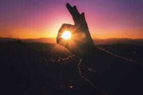 hand in front of a sunset