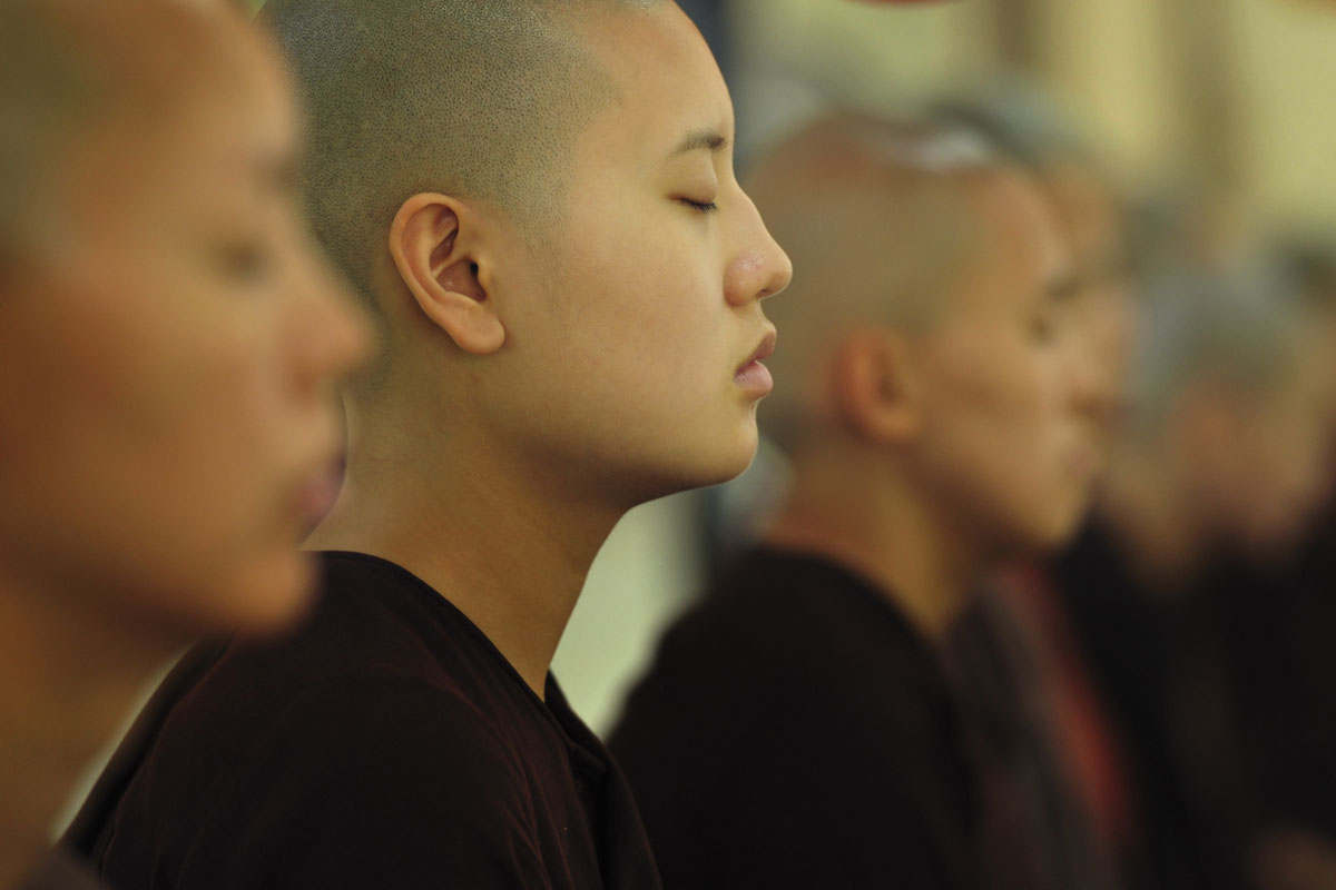 young buddhist monk with eyes closed
