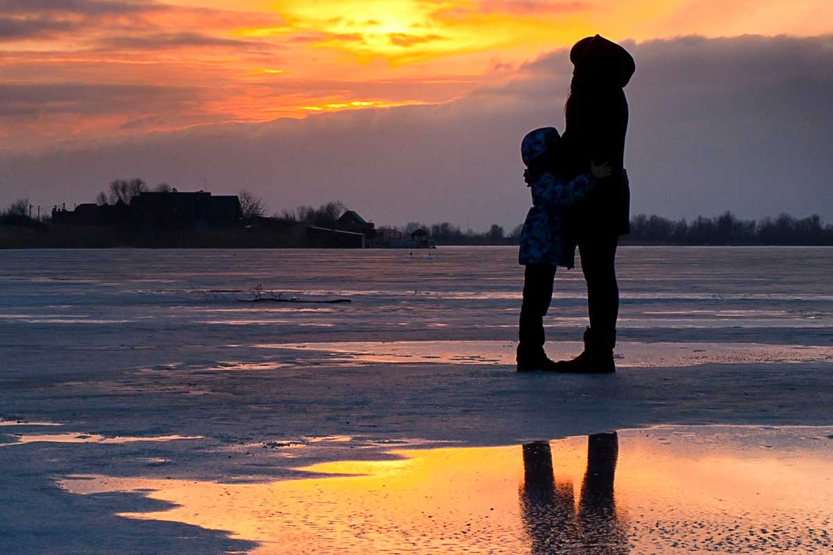parent and child embracing during sunset