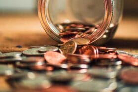 jar of coins spilling on a table