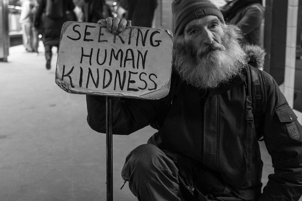 homeless man holding a sign