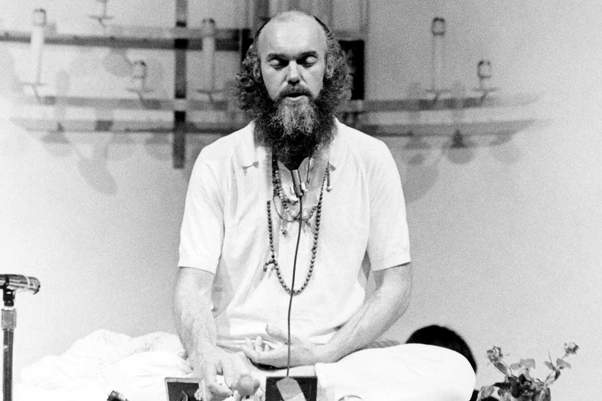 ram dass eyes closed on stage
