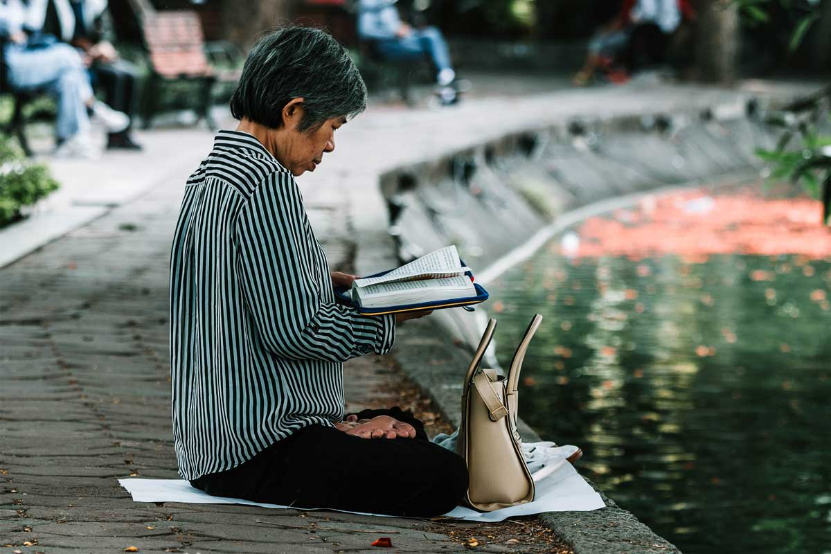 woman reading by a pond