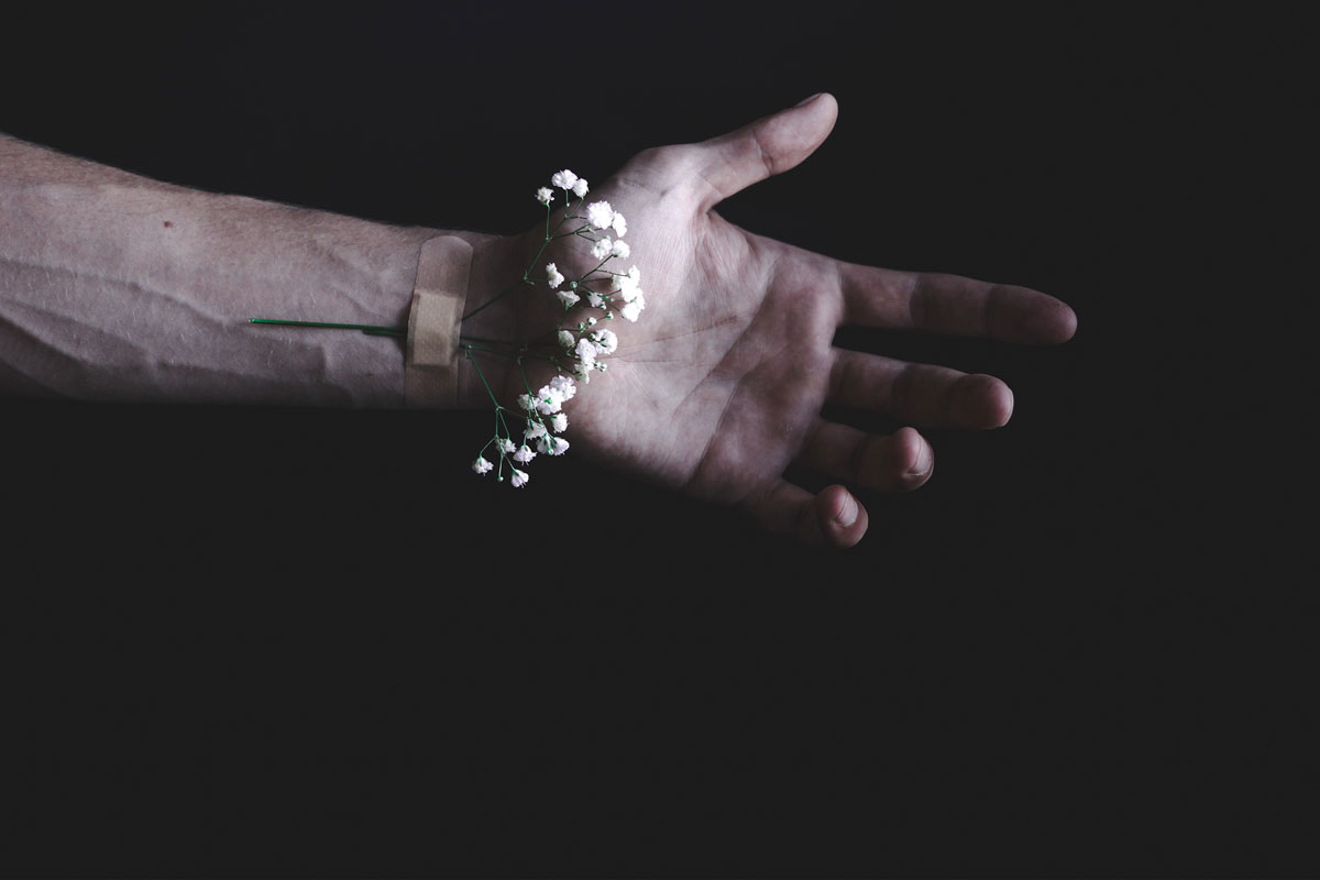 hand with flowers taped onto the wrist