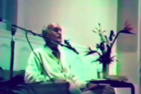 ram dass lecturing on stage