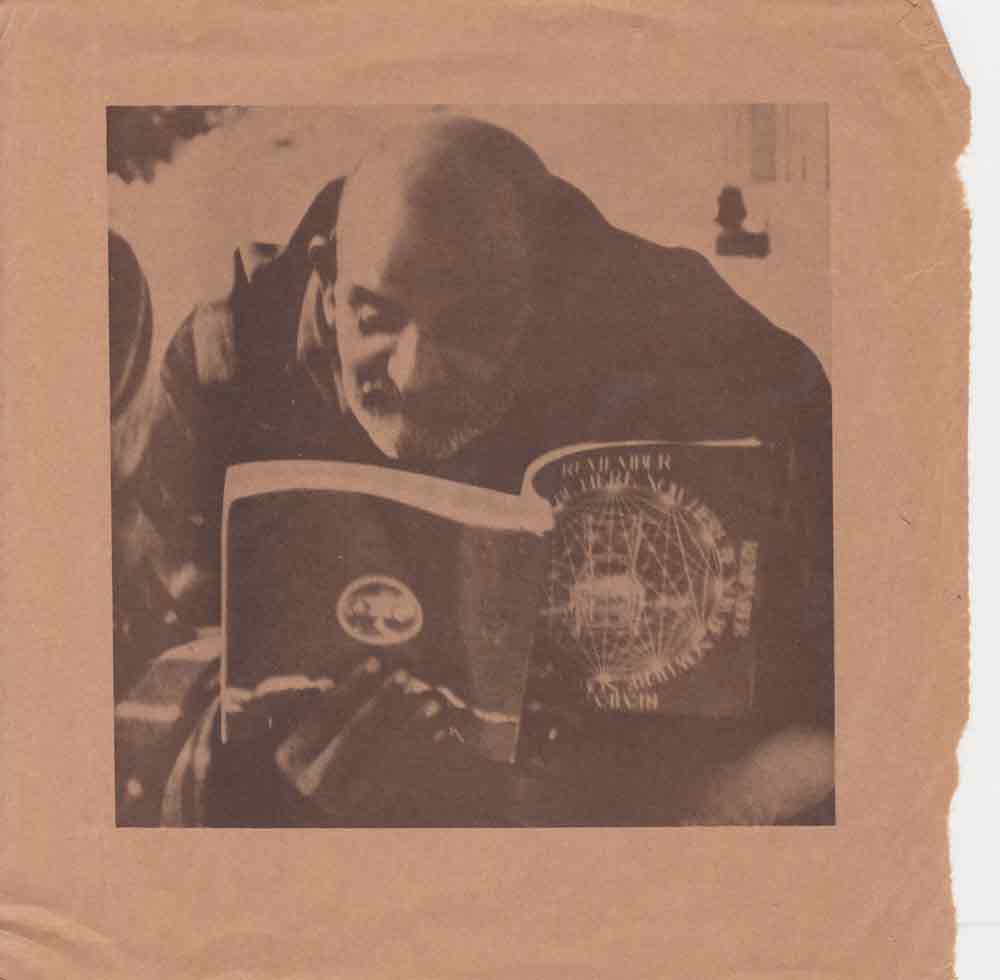 Neem Karoli Baba (Maharajji) holding a copy of 'Be Here Now'